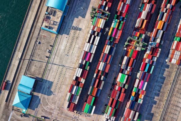 Top view of colorful shipping containers at a bustling port in Jakarta, Indonesia.